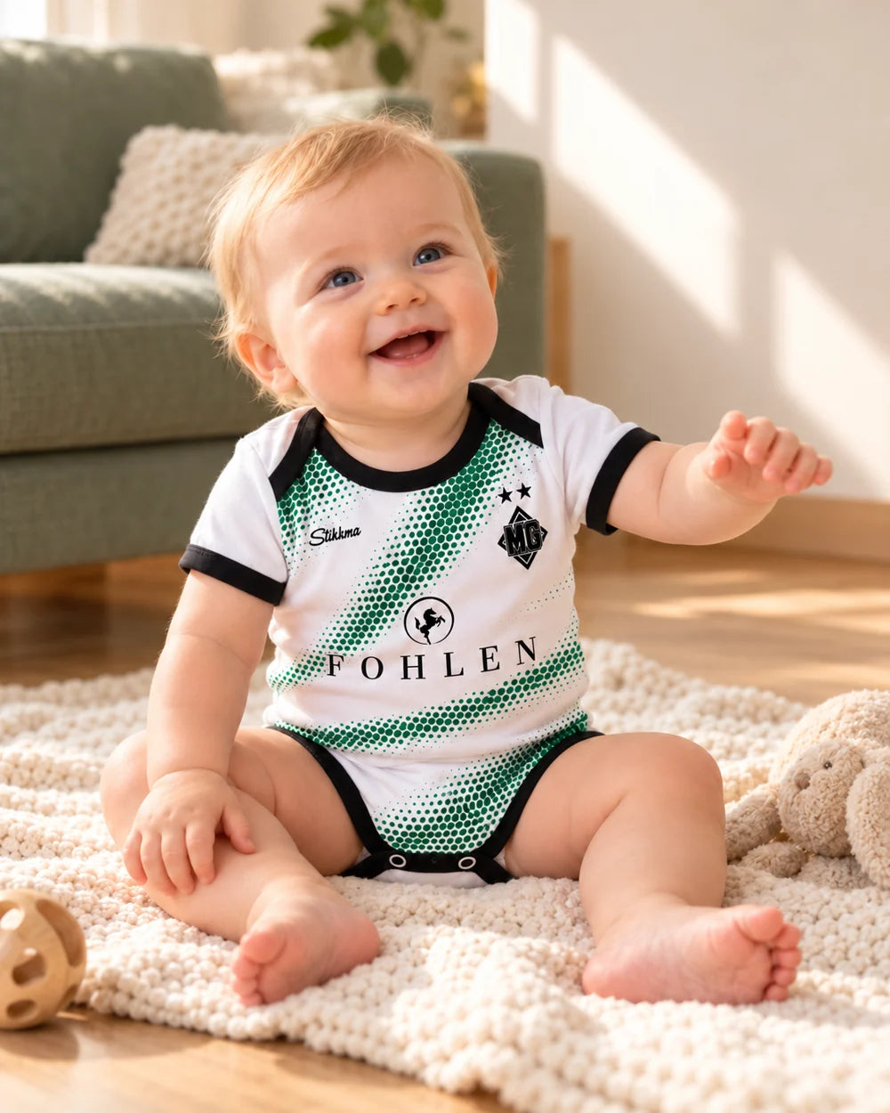 Fröhliches Baby im Gladbach-Heimbody 26/27 mit schwarzen Bündchen, exklusive Startseitenaufnahme